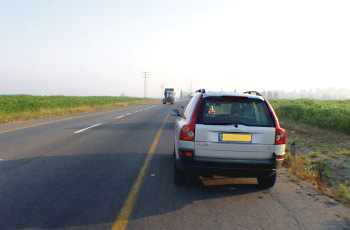 תמונה לשאלת תיאוריה: אתה מתכוון להתחיל בנסיעה לאחר עצירה או חנייה בצד הכביש. כיצד תנהג?