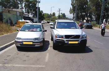 תמונה לשאלת תיאוריה: האם מותר להעמיד רכב לצד רכב אחר החונה בצד הדרך?